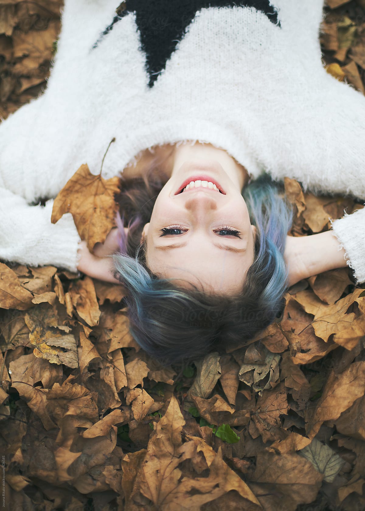 Portrait Of A Beautiful Young Woman Lying Down In Autumn Leaves And Smiling By Stocksy 