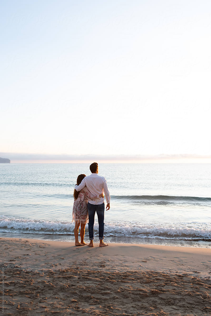 Unrecognizable man and woman admiring sea during evening date