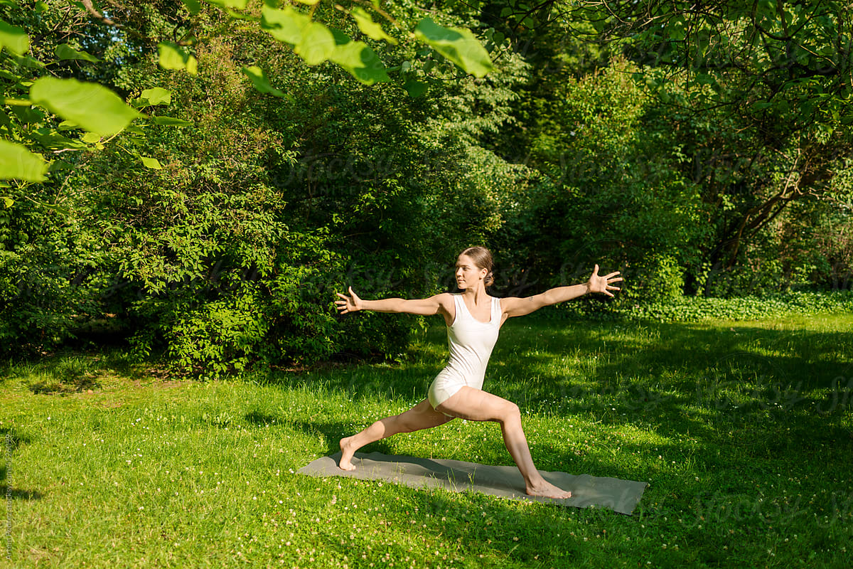 A woman does yoga and enjoys the beauty of nature. warrior two pose