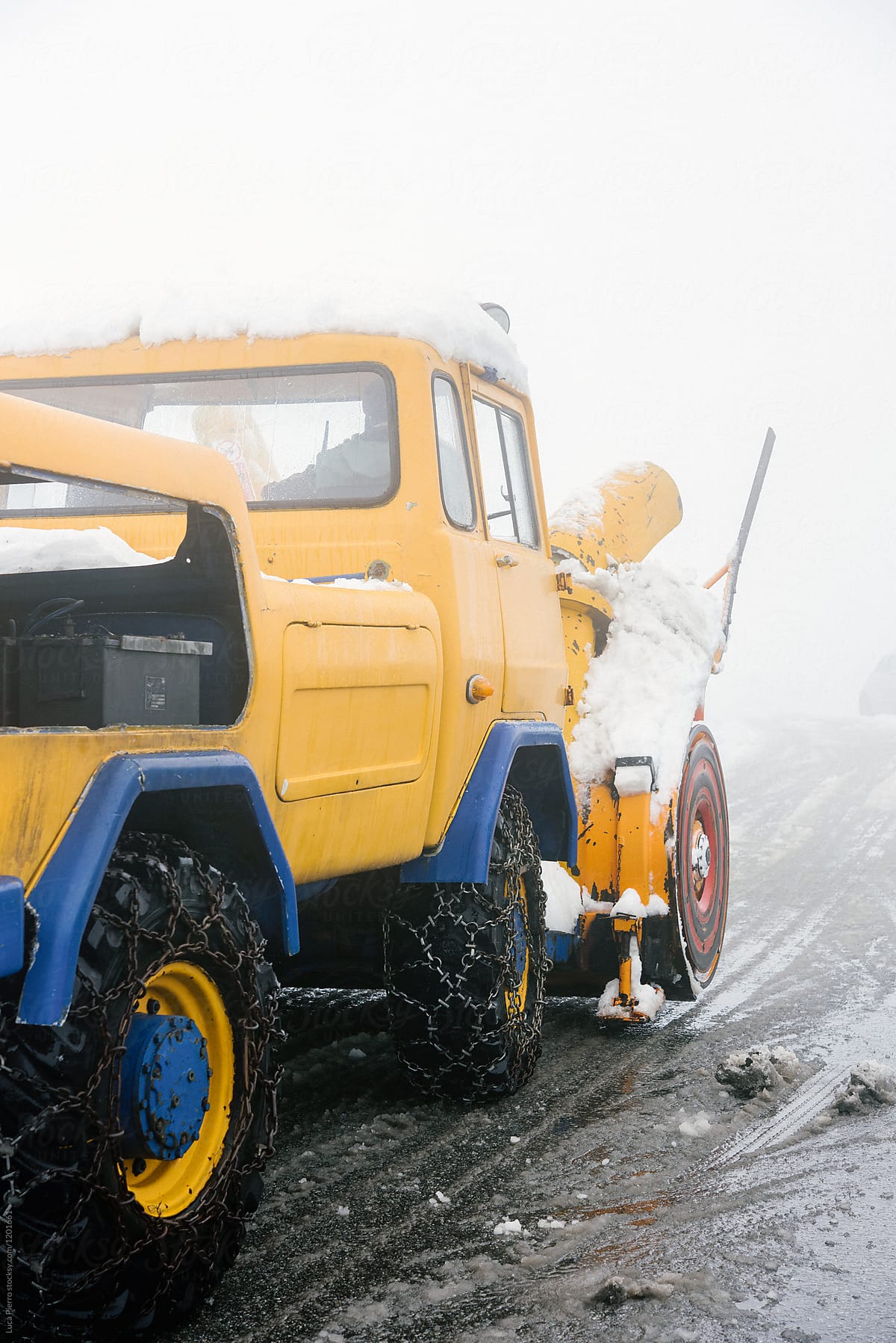 A snow plow  tractor clearing the snow on the roads from a winter storm