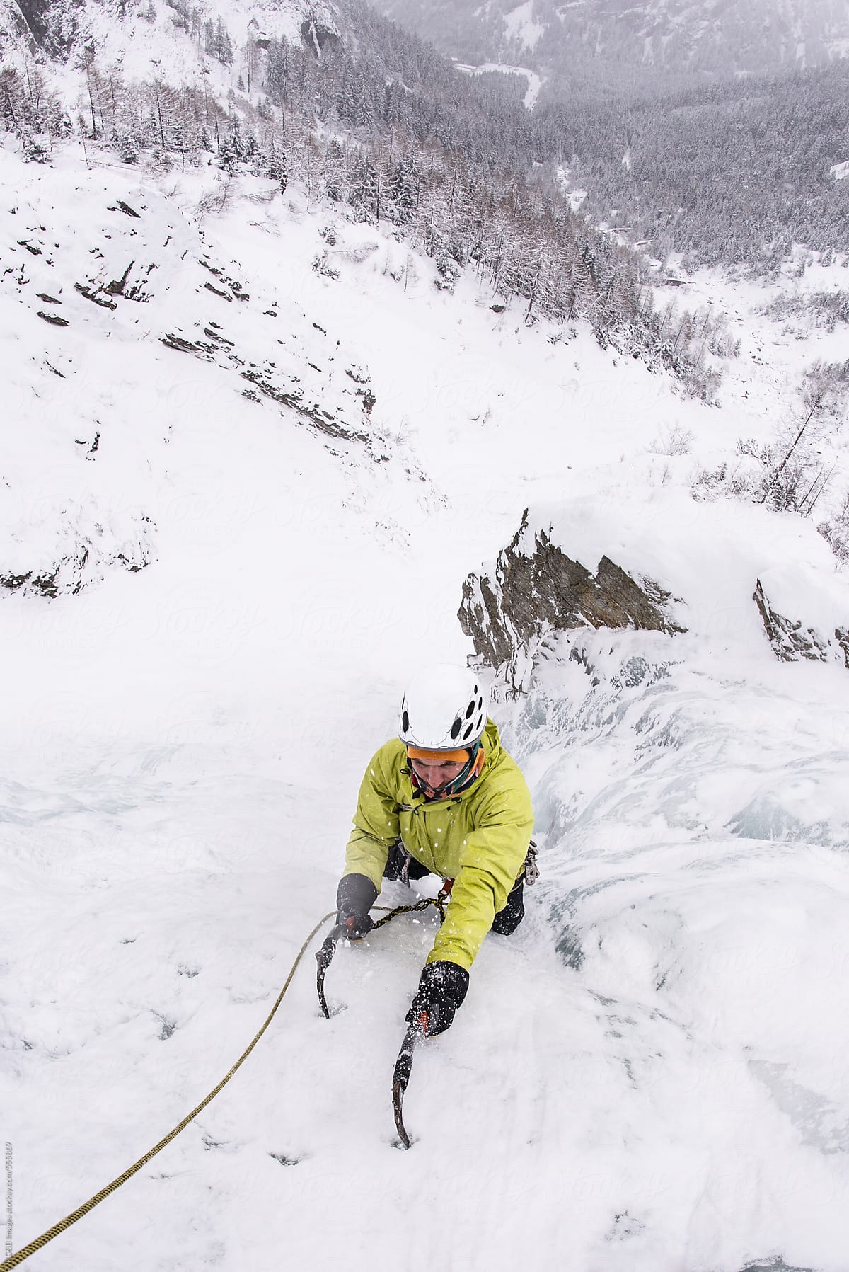 Mountaineer climbing on a frozen waterfall
