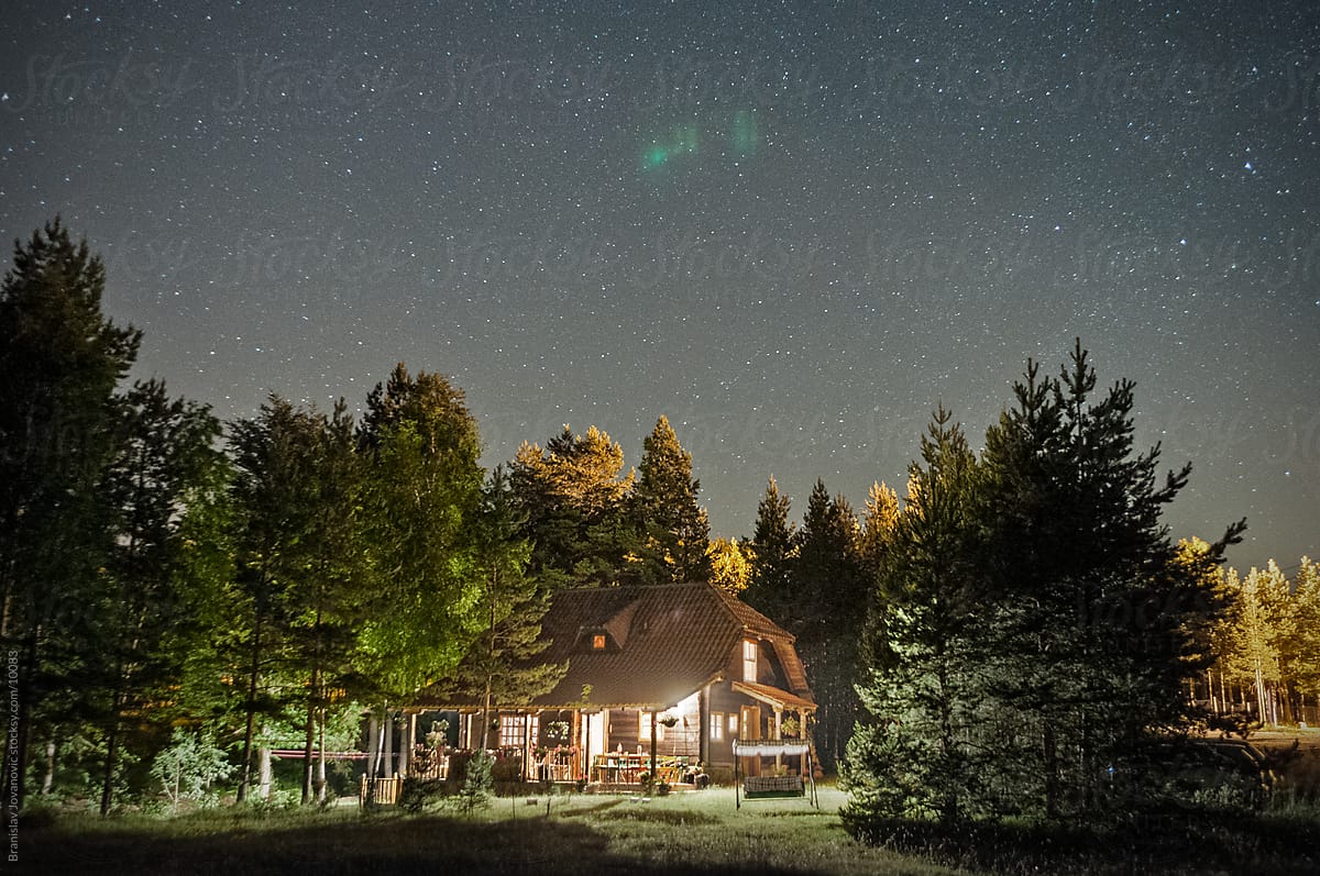 Mountain house in the woods with a starry sky