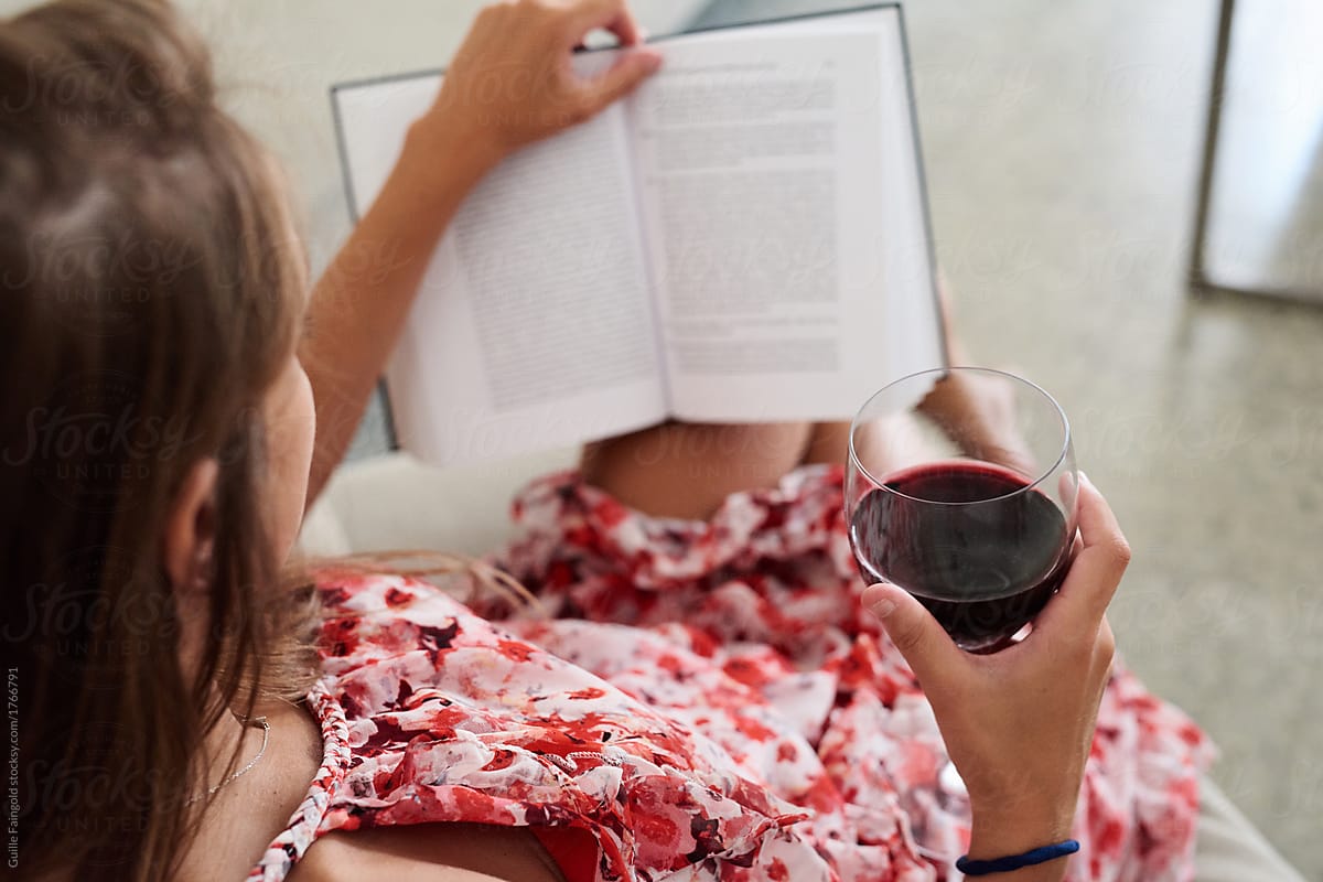 Woman relaxing with wine and book