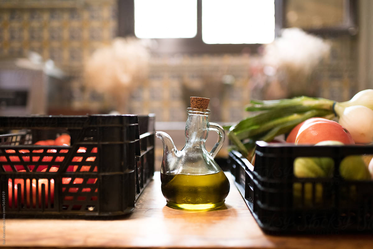 Olive oil bottle and fresh vegetables on rustic table