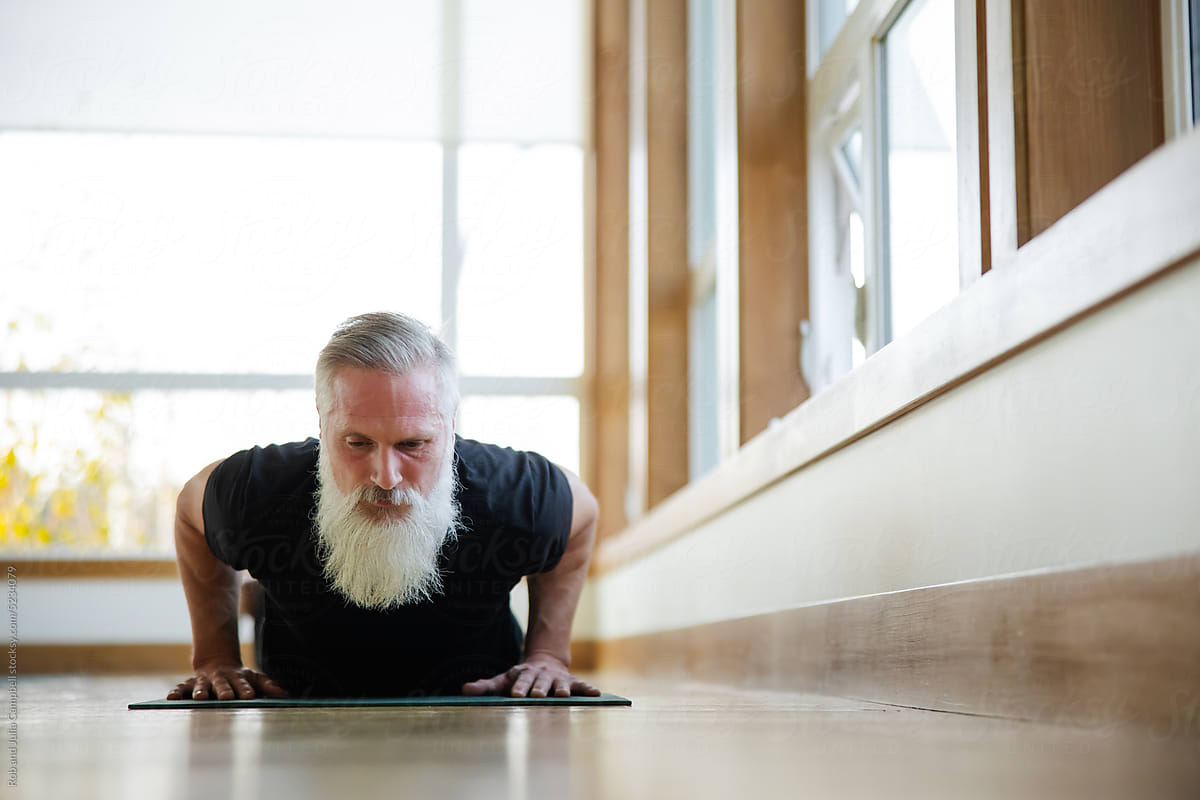 Man with white beard in yoga flow.