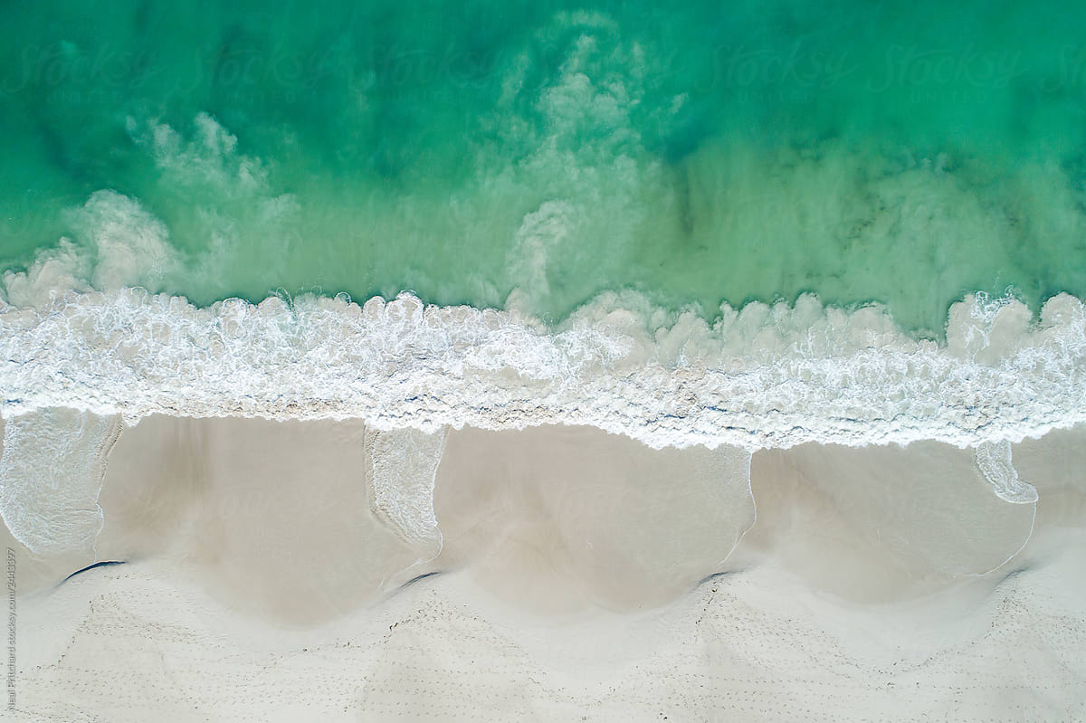 Aerial image of summertime beach scene of white sandy beach and clear clean turquoise waters