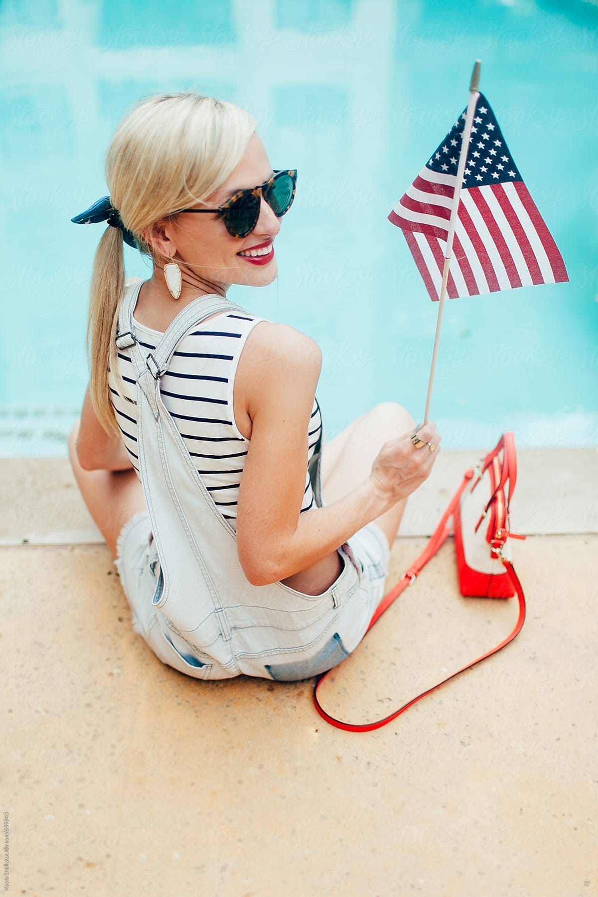 A young woman celebrates fourth of july by the pool