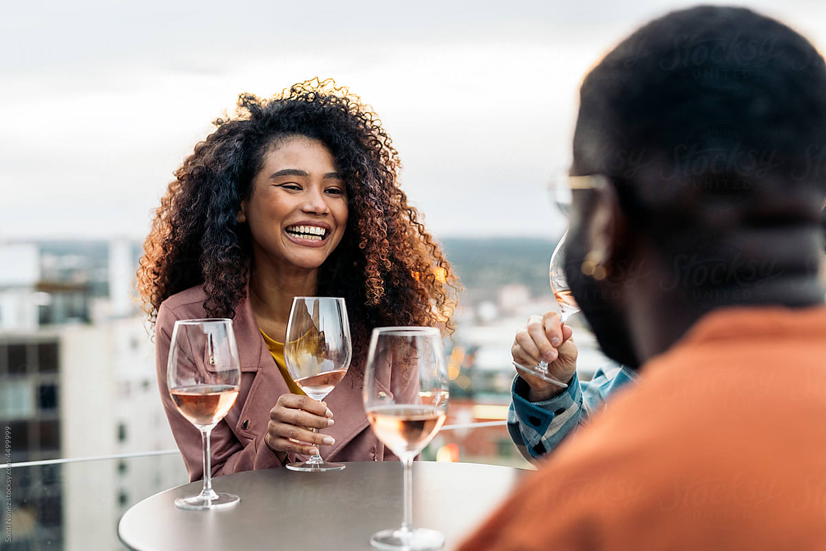 Positive black friends enjoying meeting on terrace