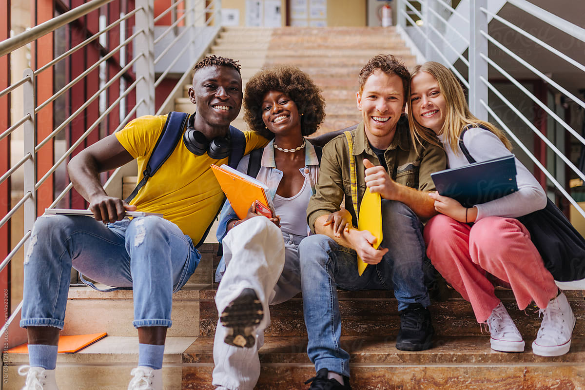 Cheerful multiethnic students sitting on stairs