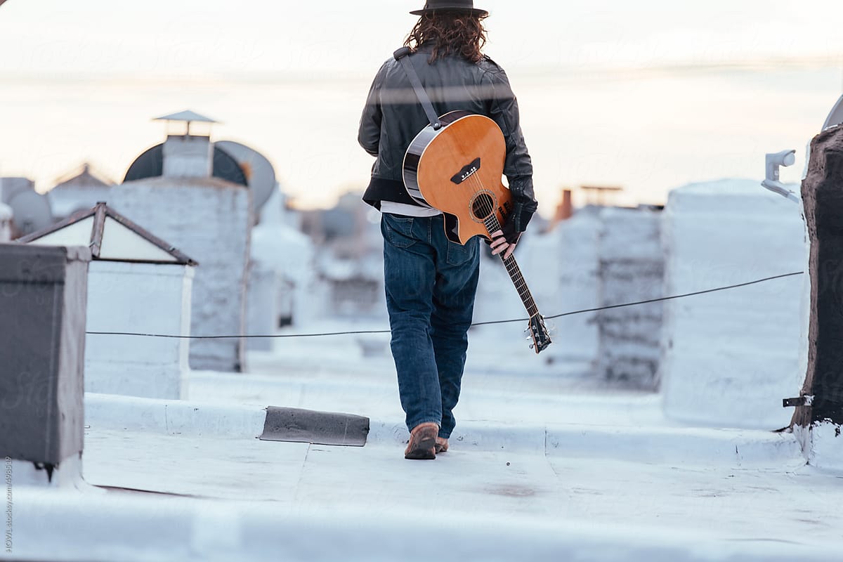Young musician has guitar on rooftop