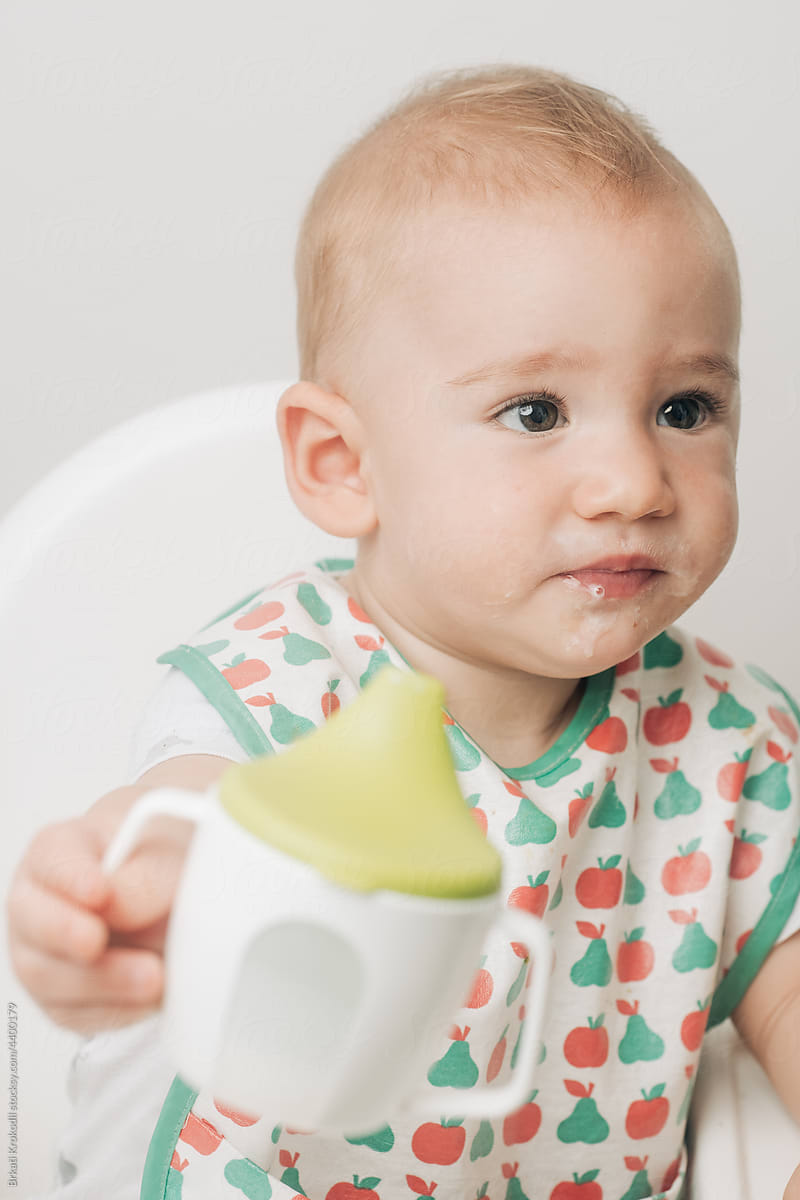 Baby Drinking From A Sippy Cup Wearing Bib