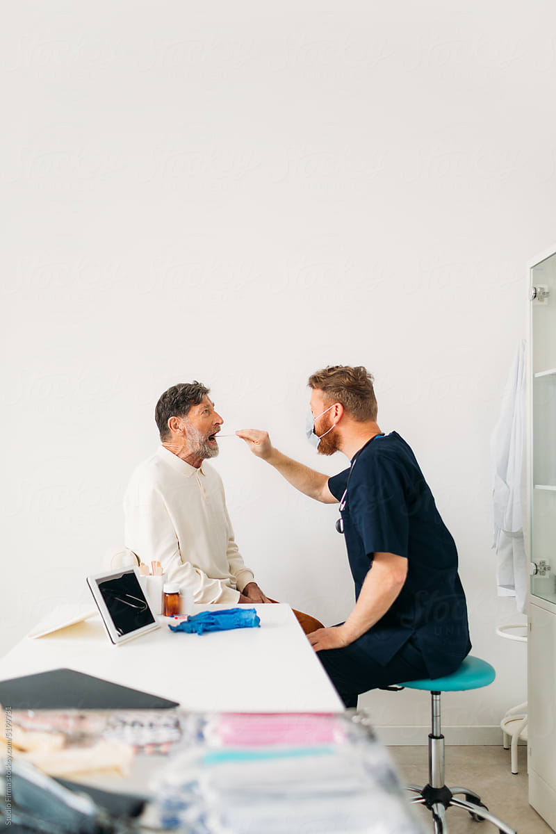 Physician Examining Man's Throat