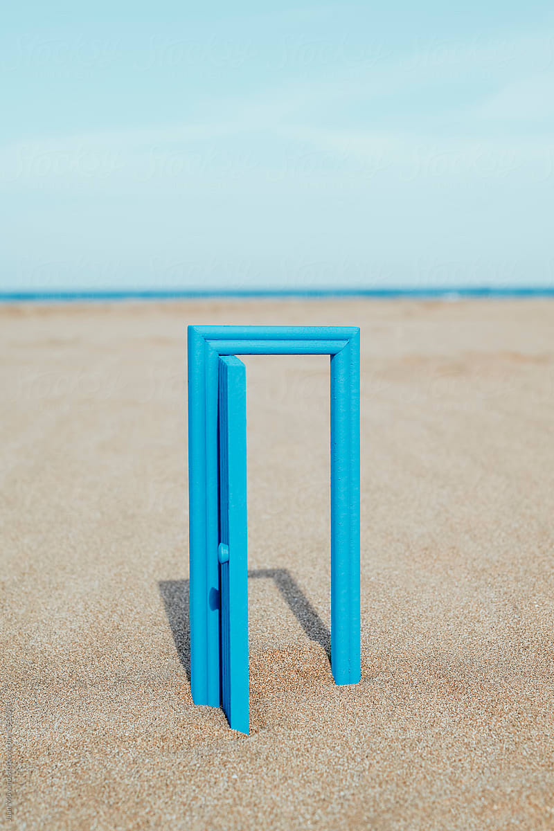 open blue door on the beach