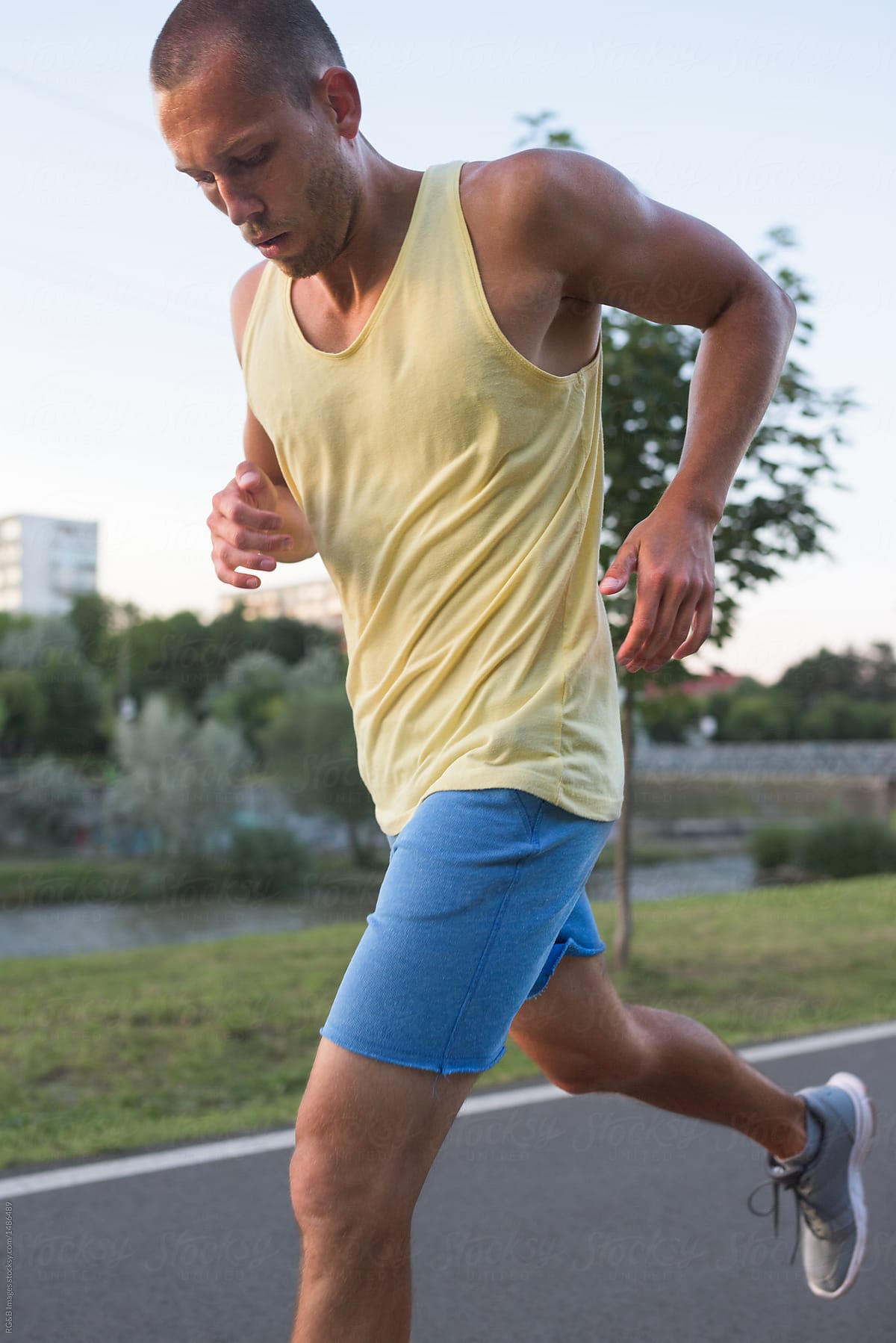 Portrait of fit caucasian man jogging outdoor in the evening