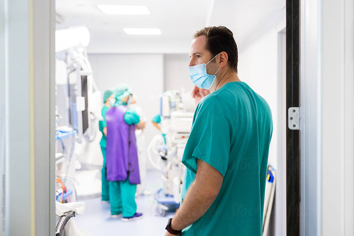 Doctor in mask standing at hospital operating room door