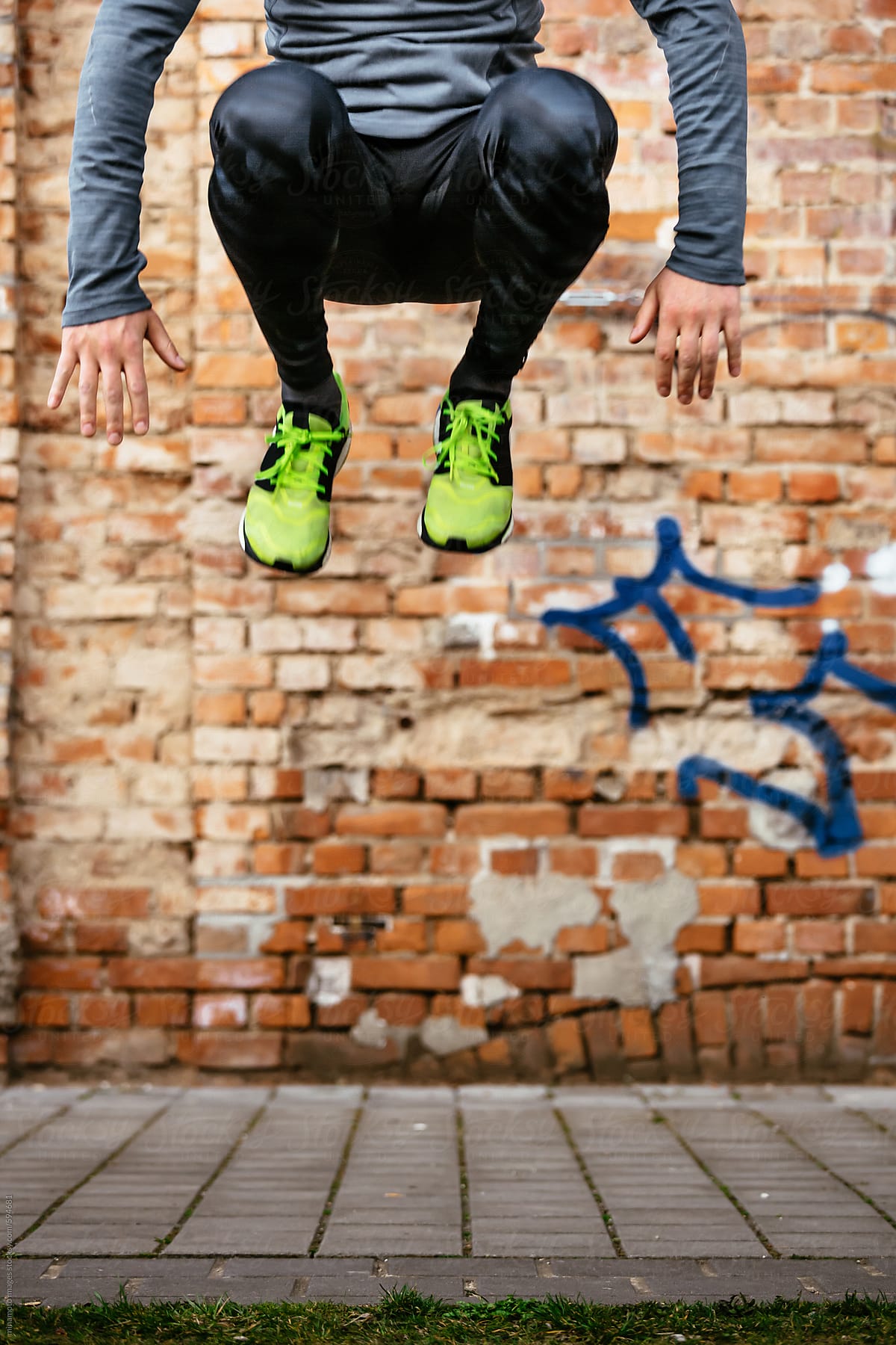 A close up of a runner\'s lower section while jumping high off the ground
