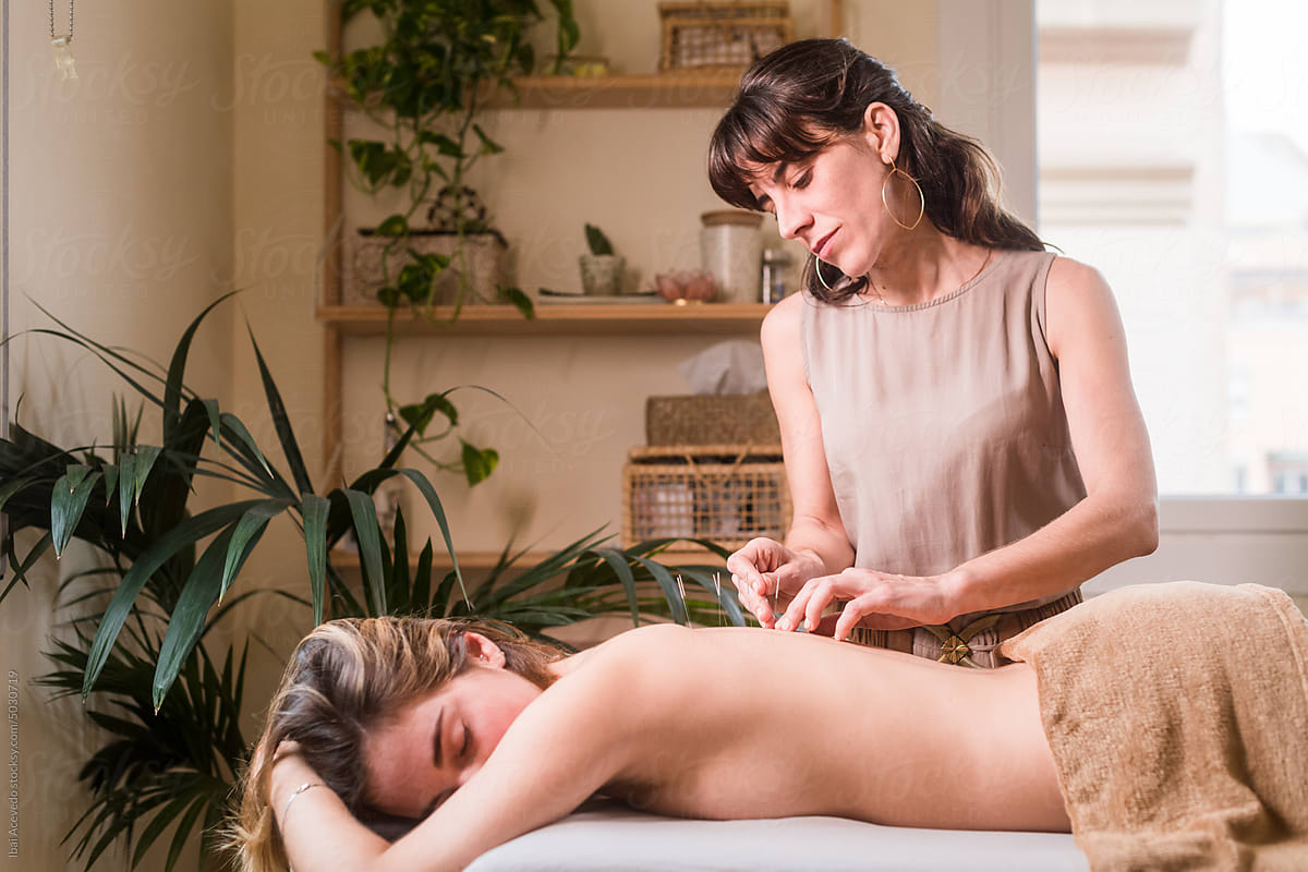 Acupuncture therapist working on woman back