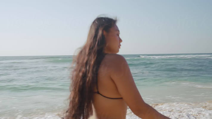 Curvy Woman Confidently Walking Down Beach In Bikini by Stocksy