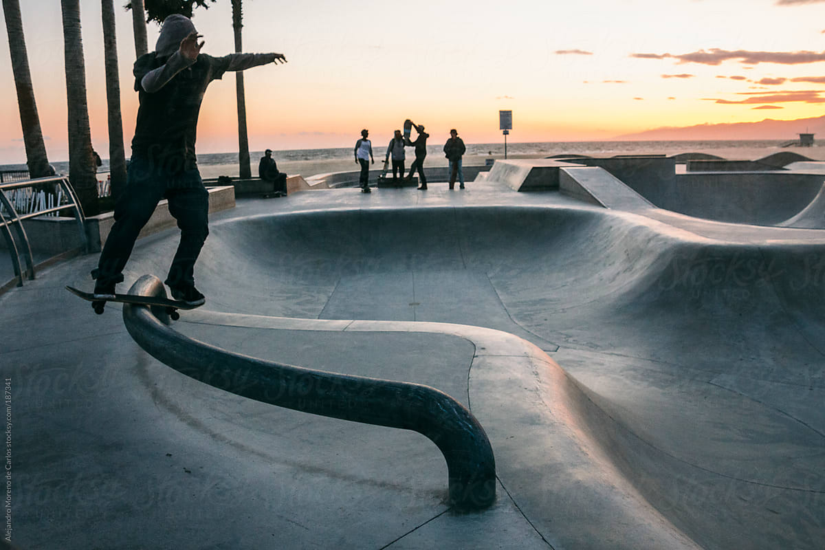Skater sliding a rail with his skateboard on a skatepark by the beach, Los Angeles, California