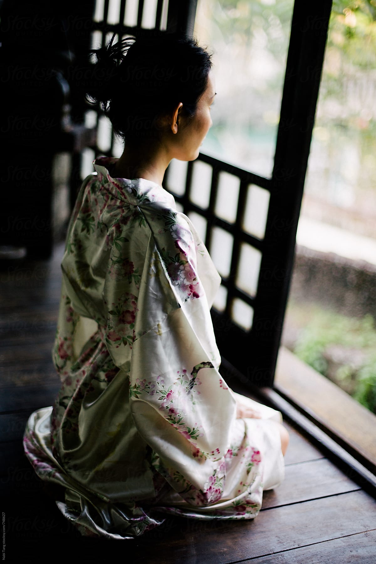 Beautiful Japanese woman looking outside to the garden