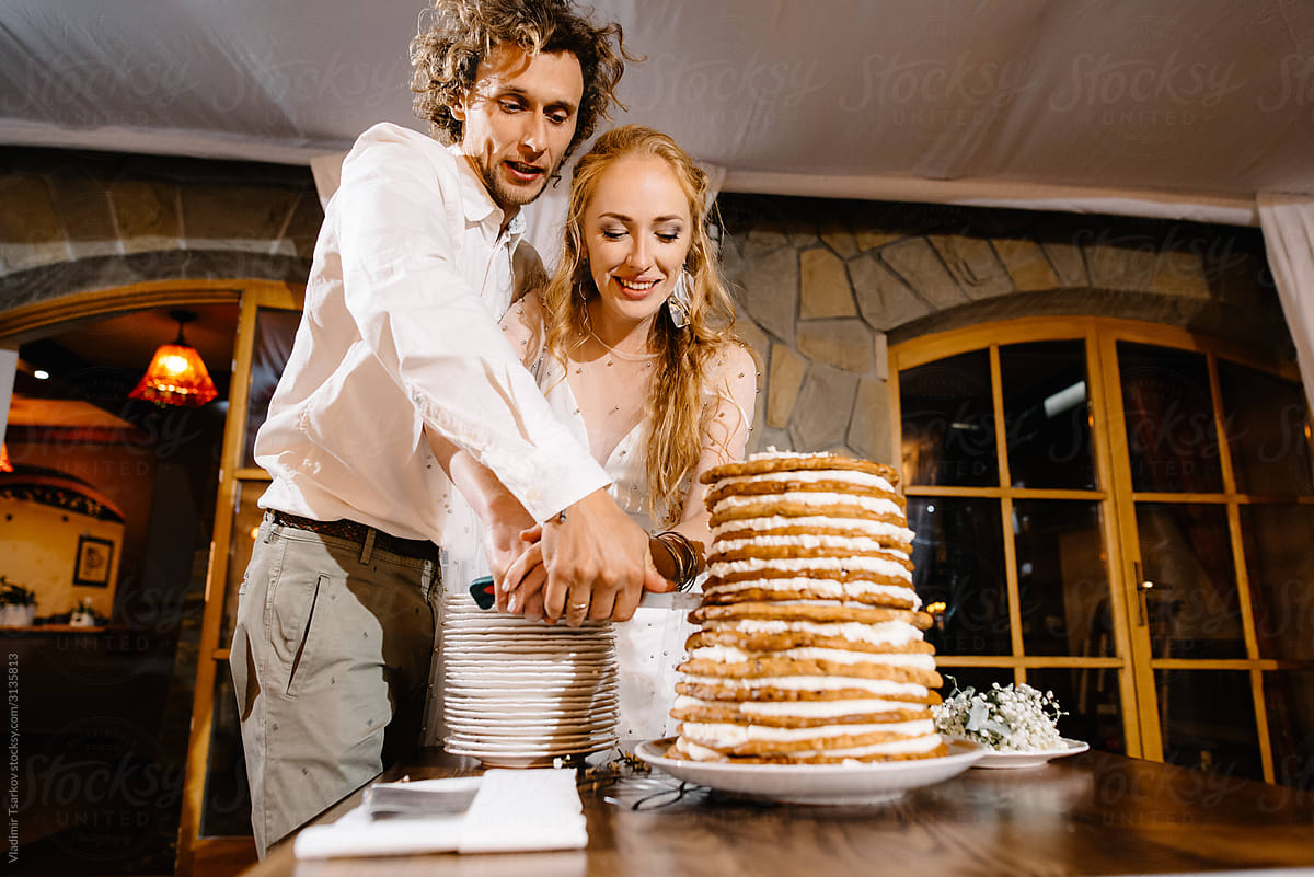 couple cutting with knife wedding cake