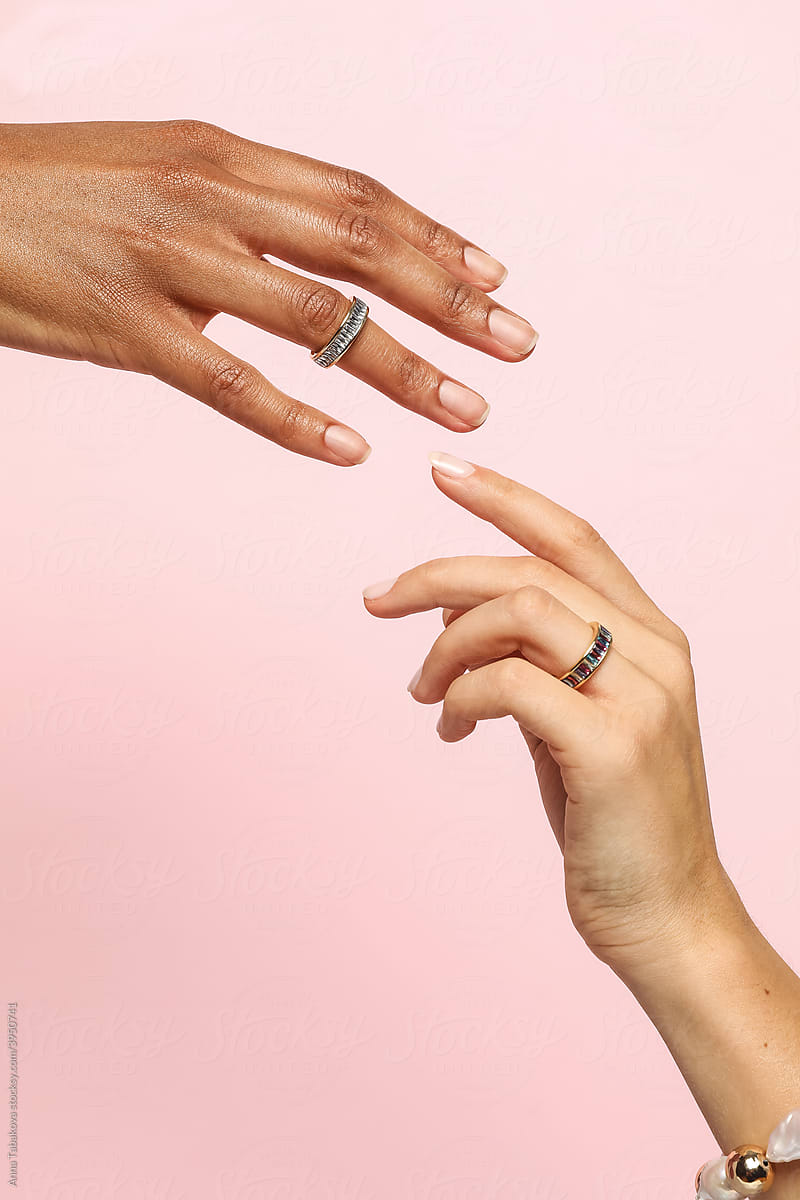 Two female hands with jewelry on holding each other
