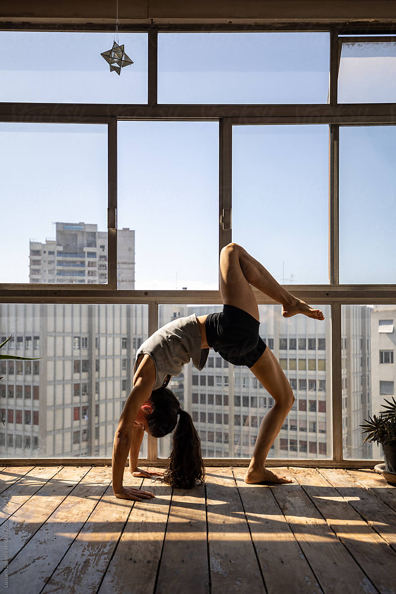 Flexibility Pose: yoga silhouette against full-height panoramic window