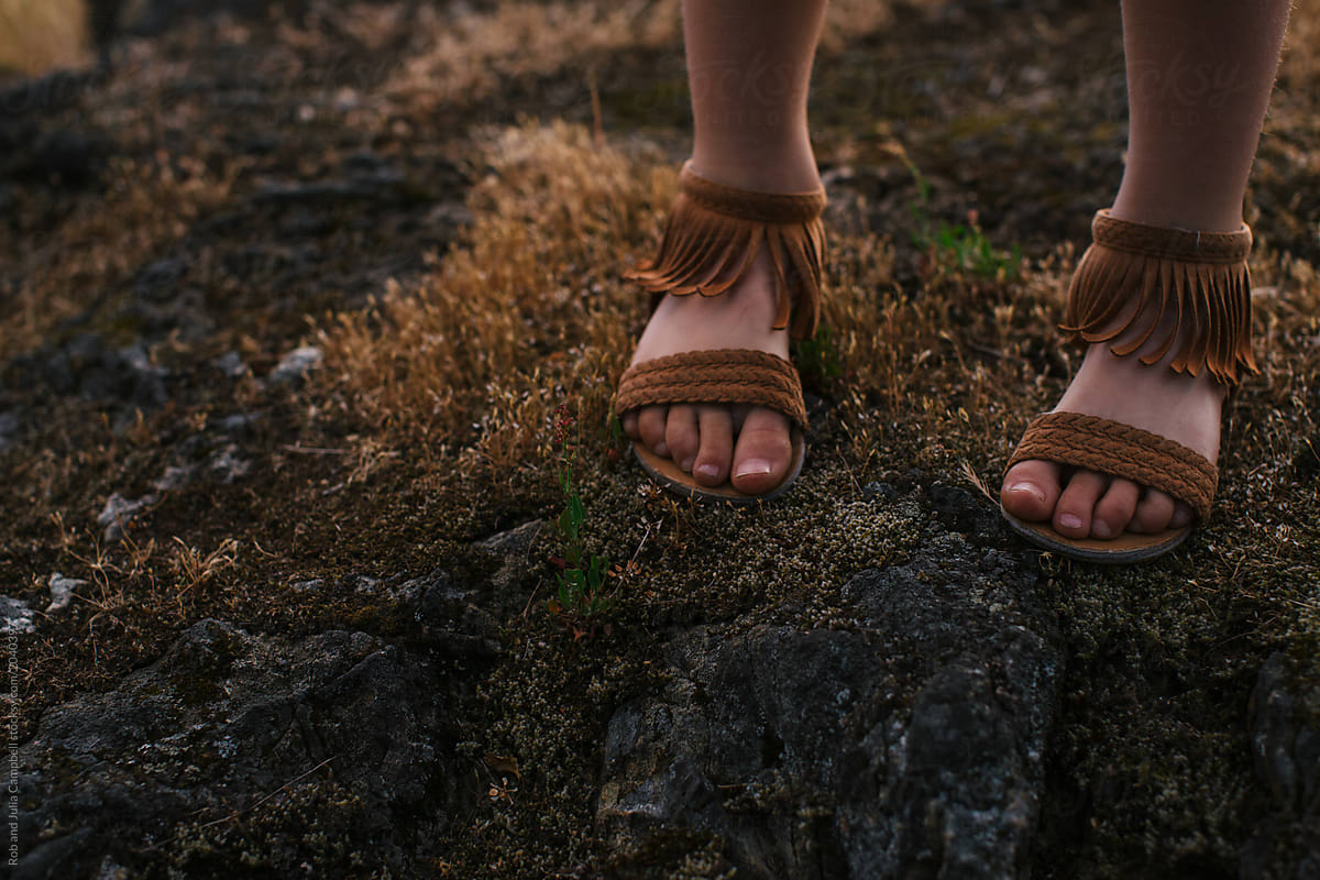 Girl's feet and sandals outside in nature