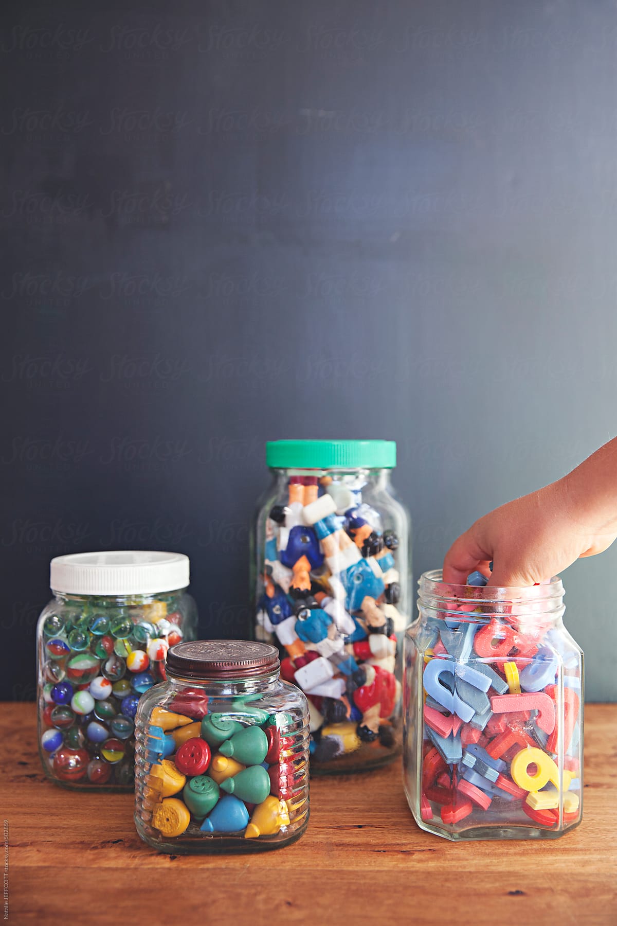 a collection of vintage toys arranged in jars on a desktop