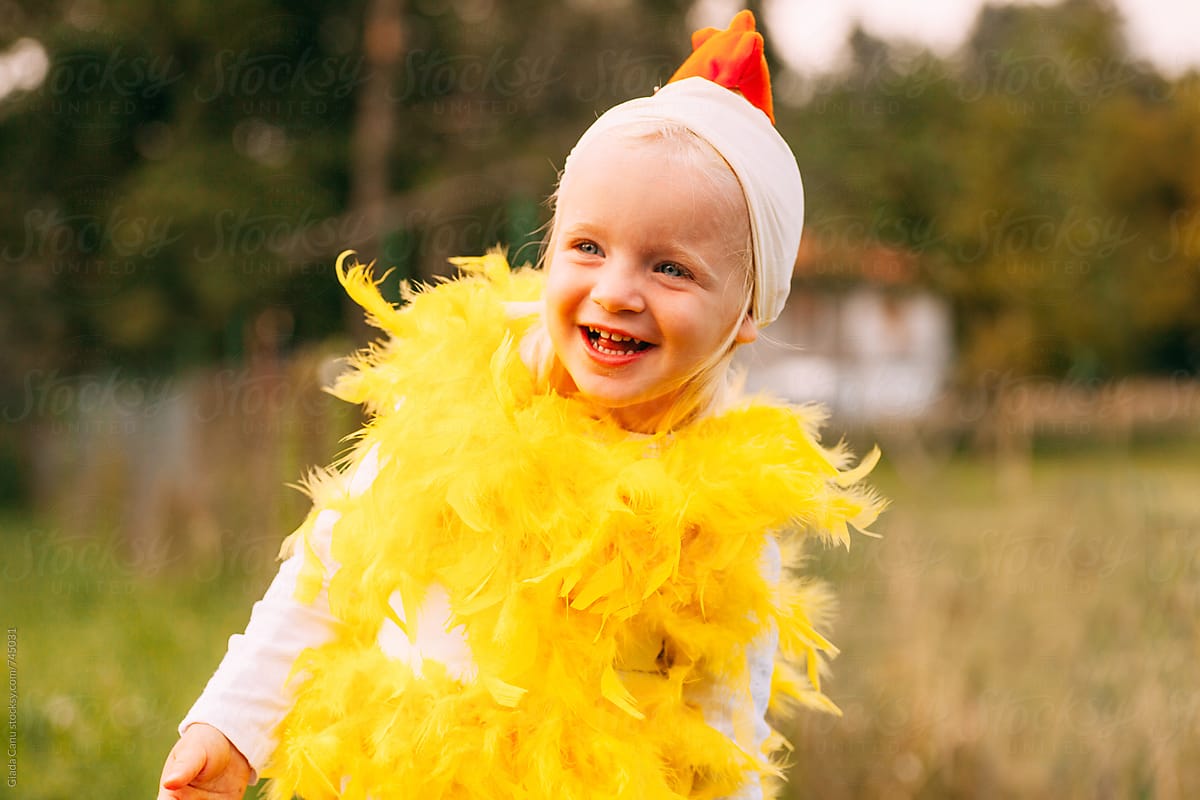 blonde toddler smiling in a chicken costume