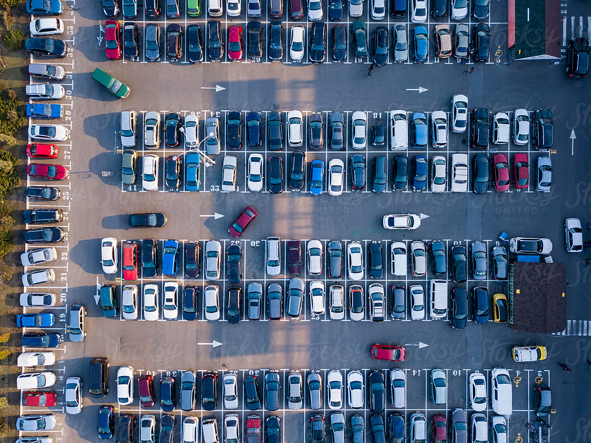 Aerial view from drone open parking with colorful cars on a gray