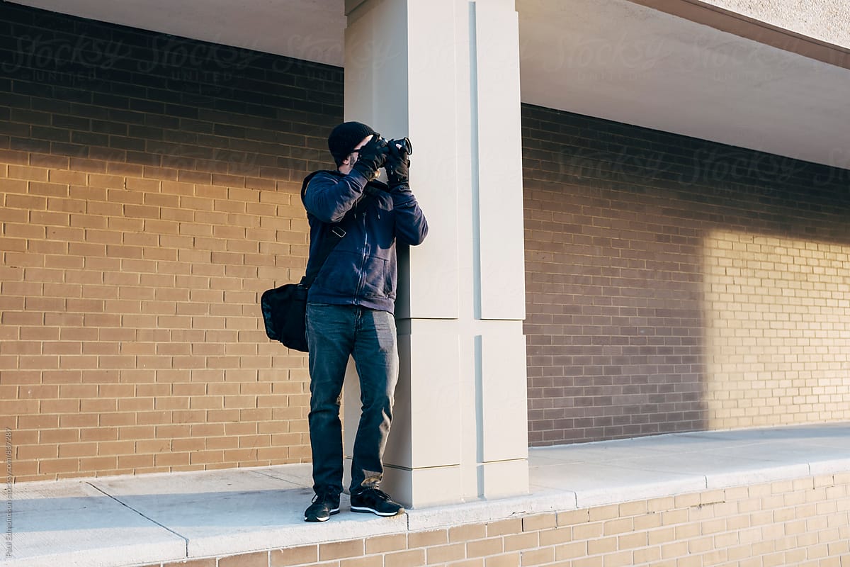 Man taking photographs near modern buildings