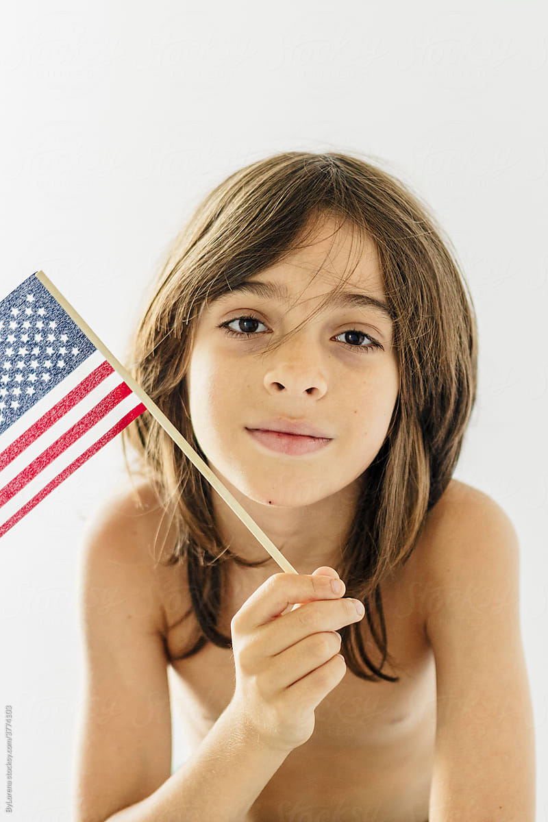 Portrait of a 10 years old shirtless holding an American flag
