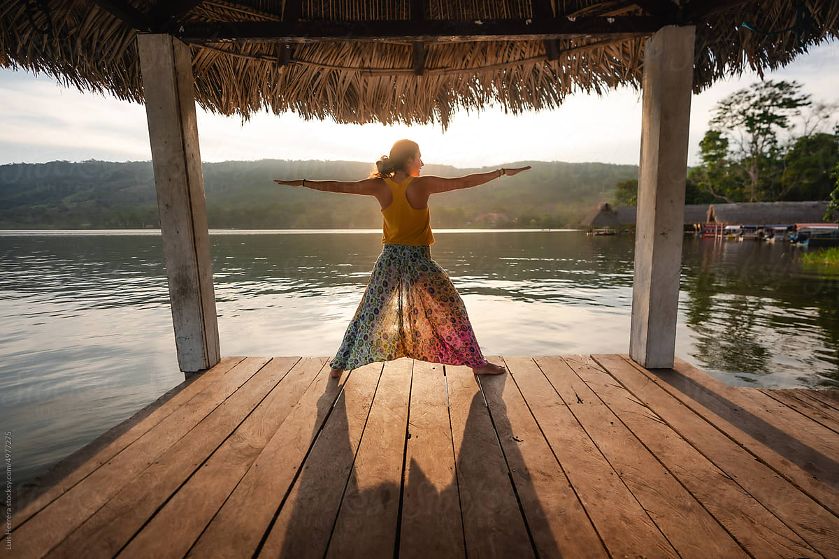 woman outdoors doing yoga by a lake
