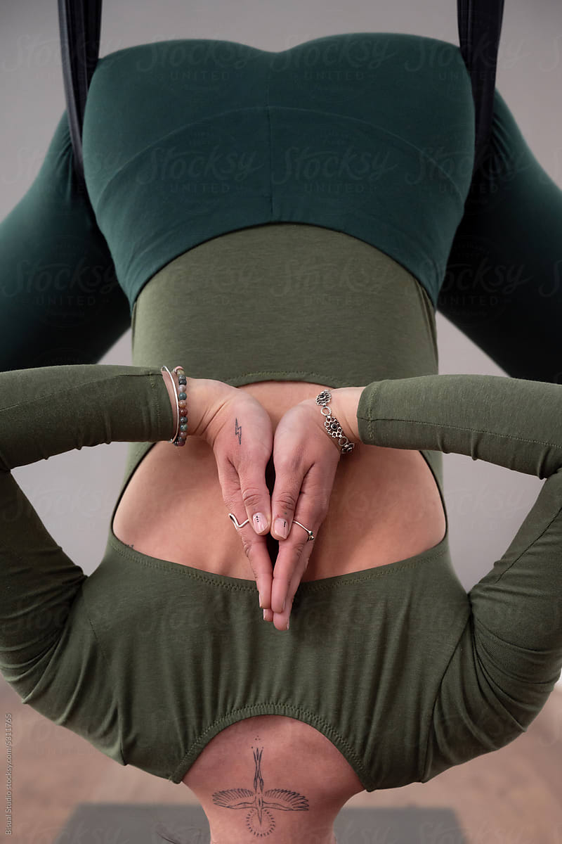 Woman practicing aerial yoga in lotus pose