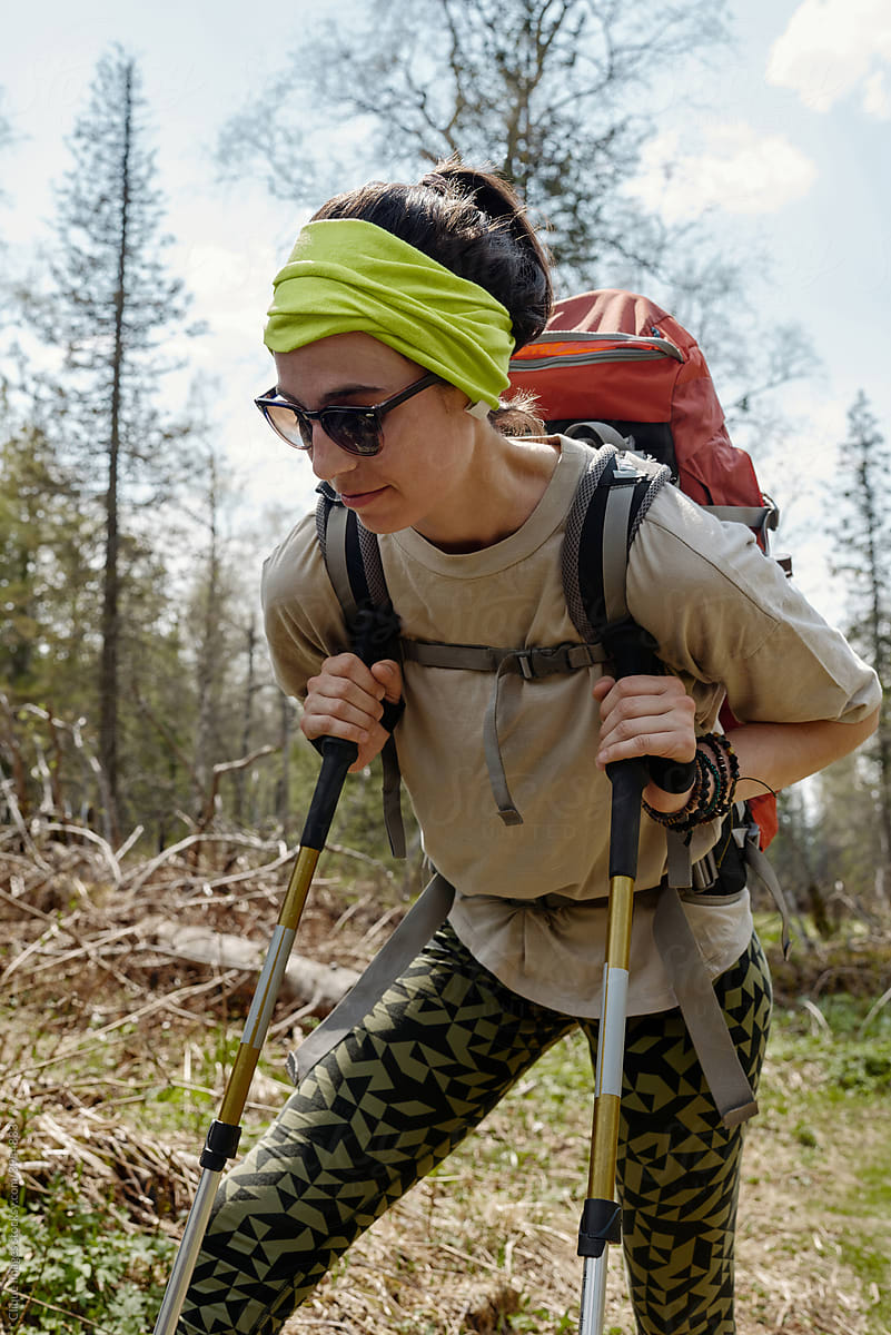 A Girl in Hiking Clothes with Trekking Poles Walks in the