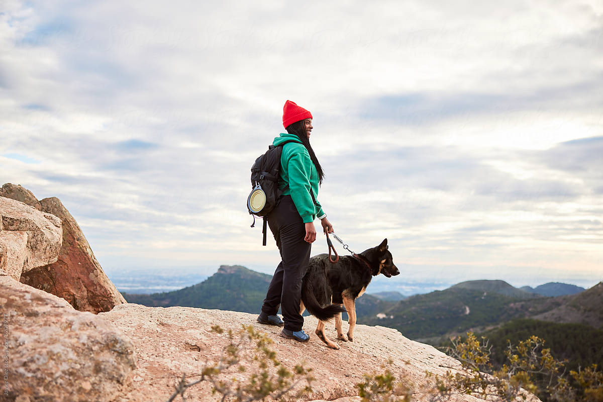 Woman with dog on rocky mountain