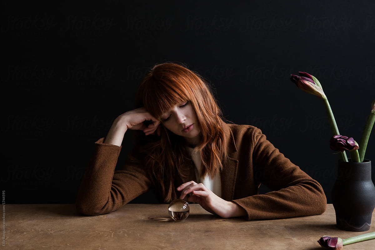 Redhead girl sitting at table