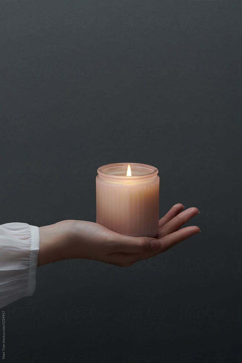 Woman hand holding handmade soy candle jar
