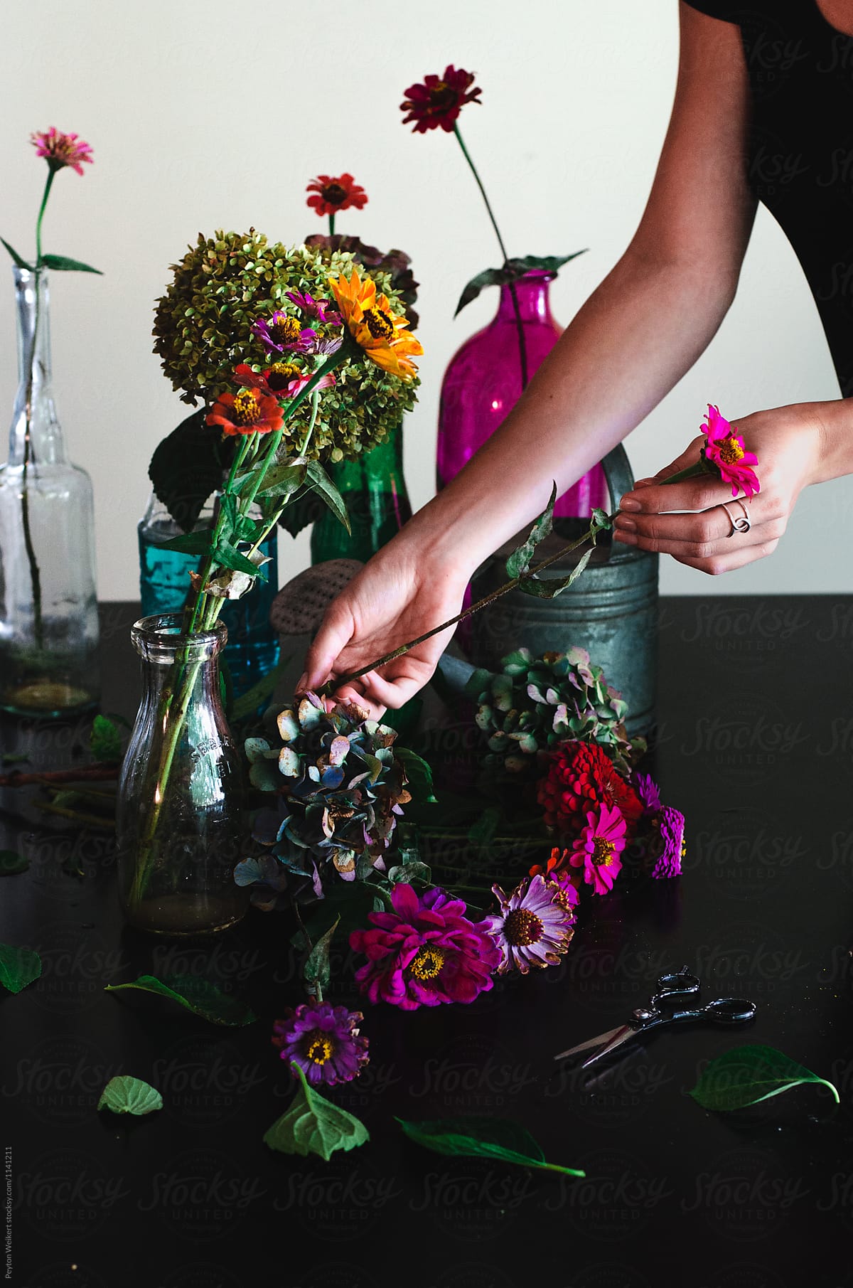 Florist Clipping Zinnias and Hydrangeas to Make Bouquets