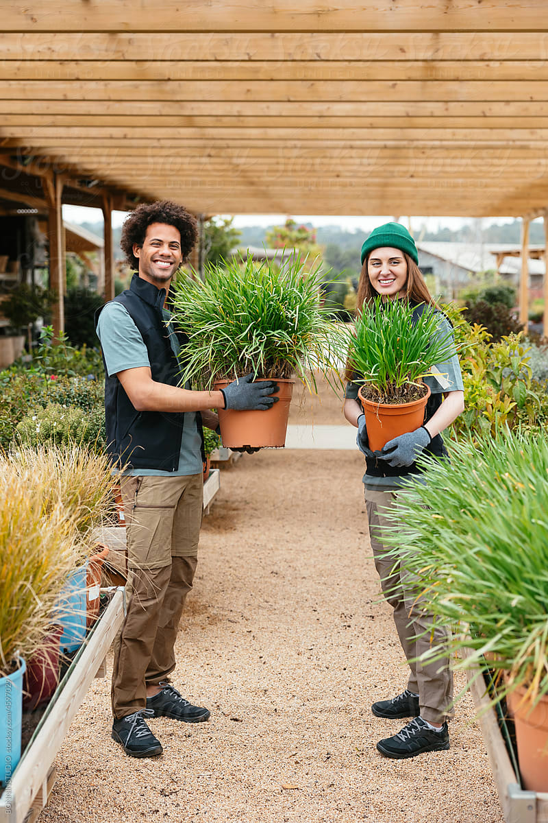 Cheerful gardeners with lush potted plants