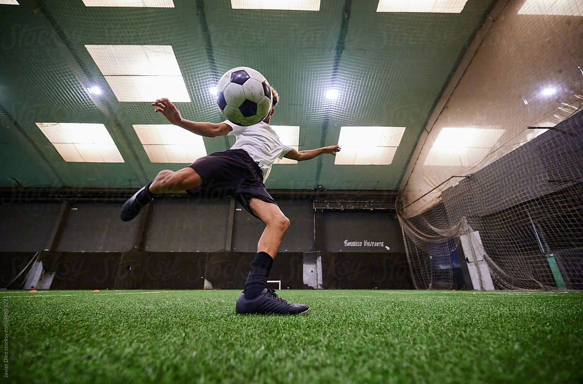 Football player kicking ball on field