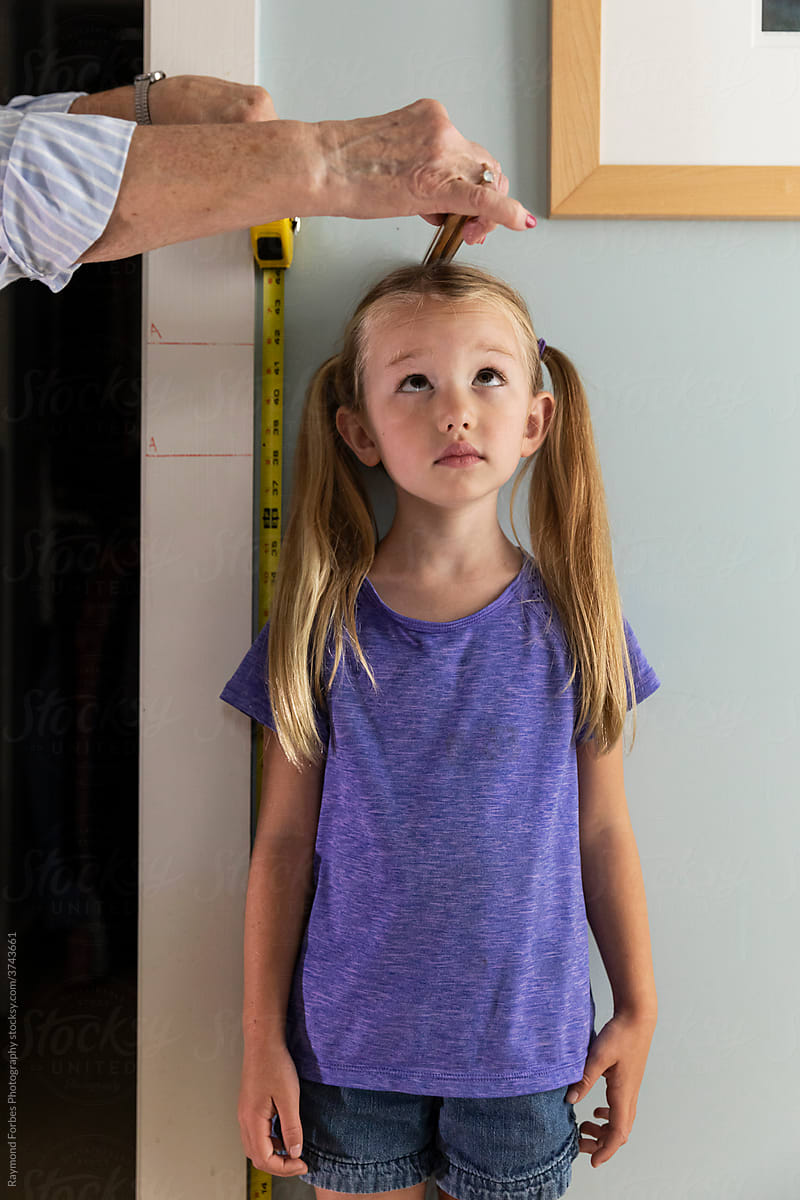 Curious Young Girl Measuring her height