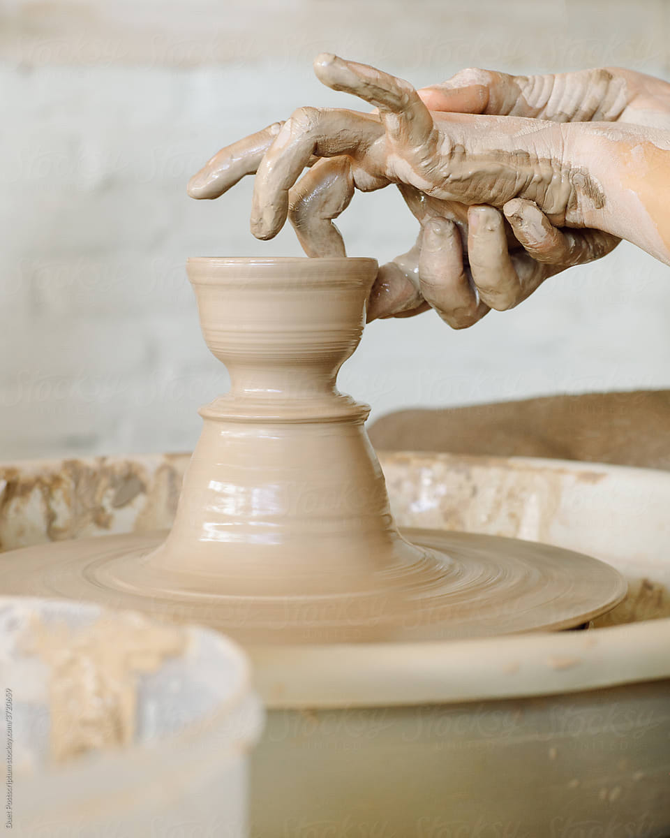 A potter makes a cup of clay on a potter\'s wheel
