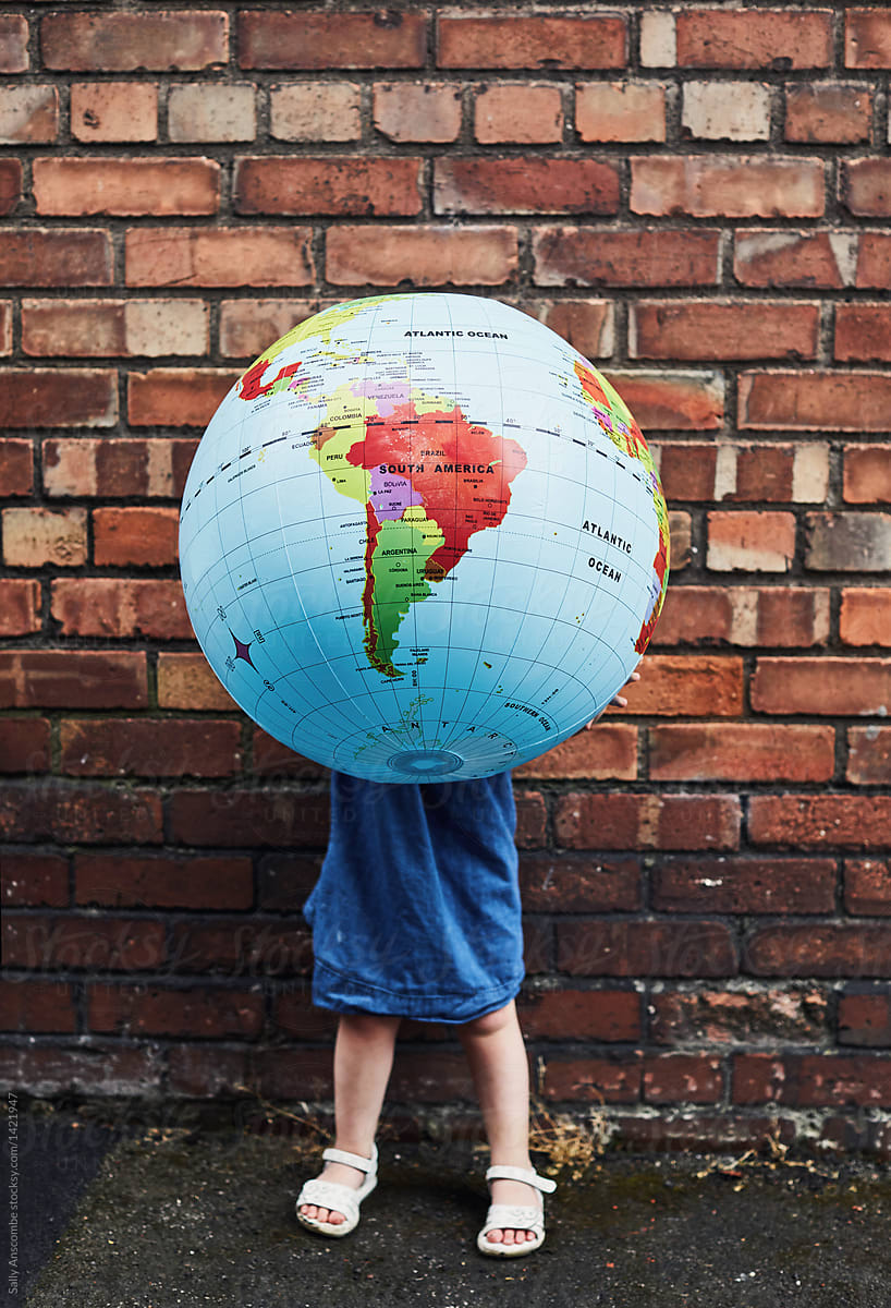 Child holding a large globe