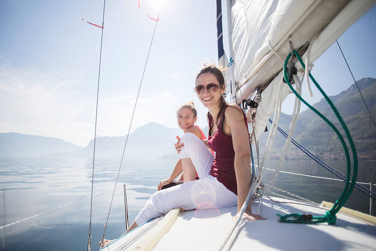 Two smiling women looking at the lake from the sail boat