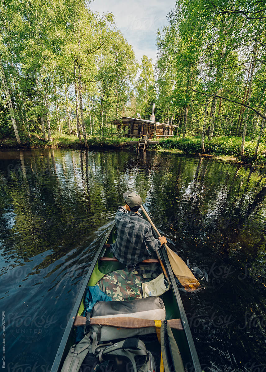 Back view of a man in a canoe during as adventure across Finland