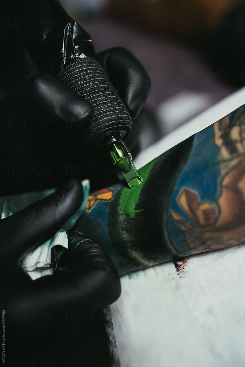 Tattooist working with client in salon