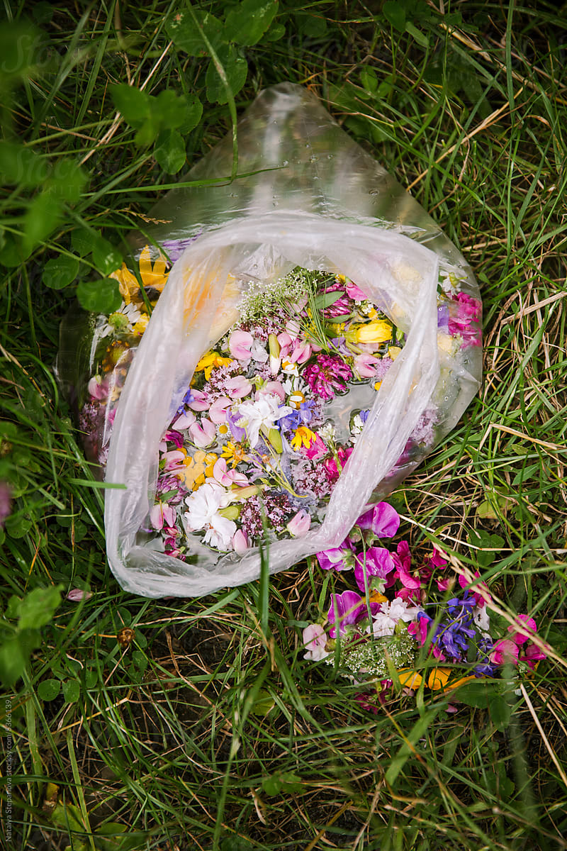 A bag of wildflowers in the water on the grass