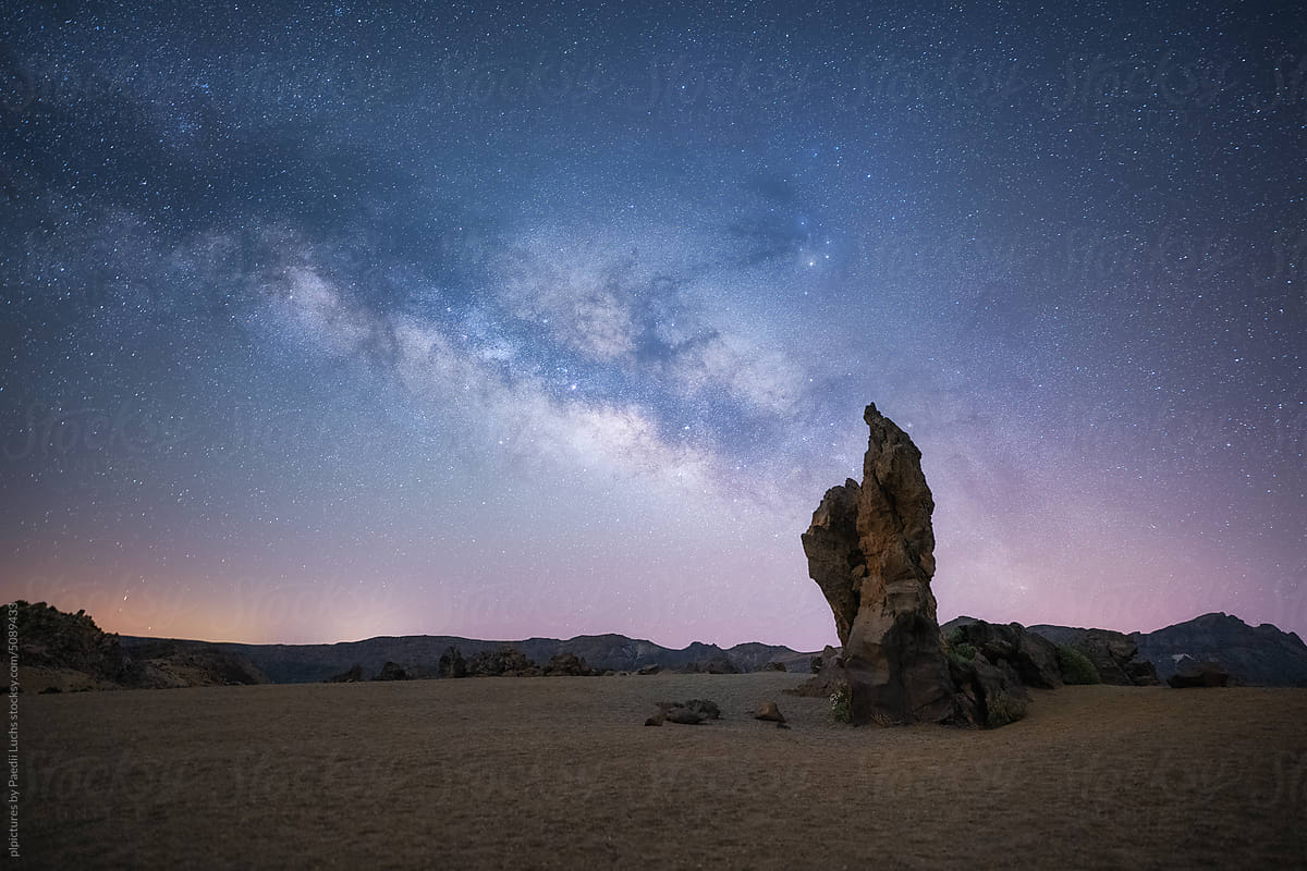 Night landscape with colorful Milky Way and rock formation.